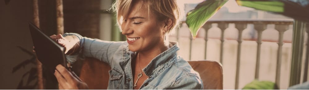 Homme frisé qui rit devant son smartphone