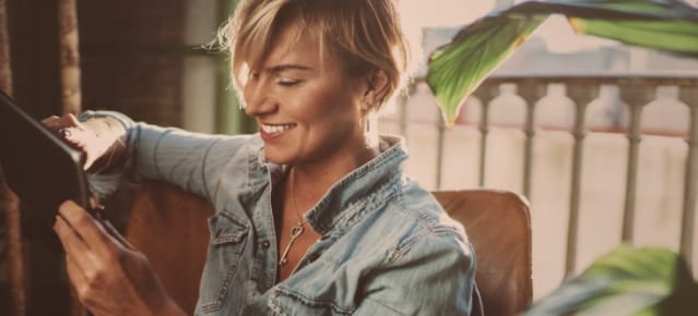 Homme frisé qui rit devant son smartphone